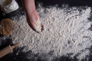 Woman hand spreading flour on table