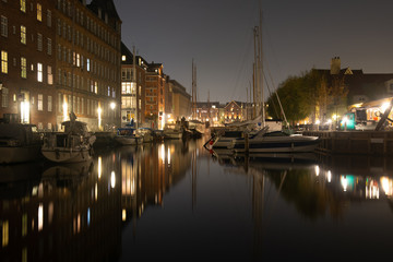 Fototapeta na wymiar Cozy christianshavn channel in the danish capital of Copenhagen. This is the harbor for many liveaboard and boats made for housing