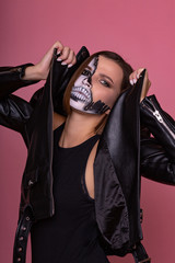 Brunette model with black and white scare face art in Halloween style