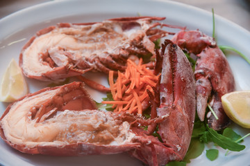 Delicious grilled lobster served with lemon and carrots .