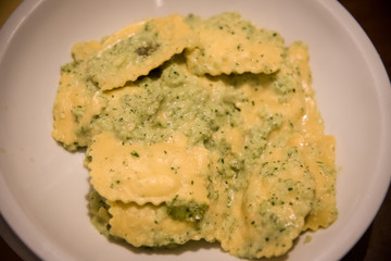 Ravioli with four cheeses on a white plate .