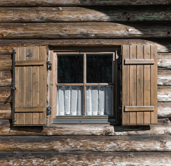 Obraz na płótnie Canvas windows with shutters in textured wooden wall
