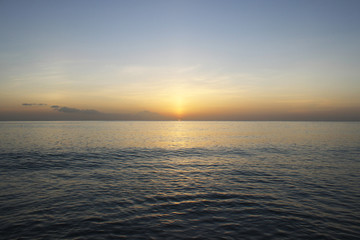 Calming and beautiful orange sunset against blue seashore
