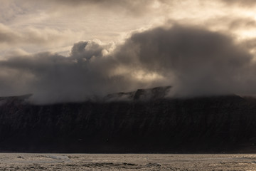 Fototapeta na wymiar textured cloudy sky over a cliff on the ocean at dawn