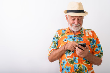 Happy senior bearded tourist man smiling while using mobile phone