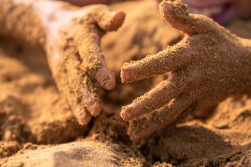 Sandy hands of a child