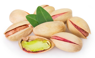 Pistachios with leaves on white background