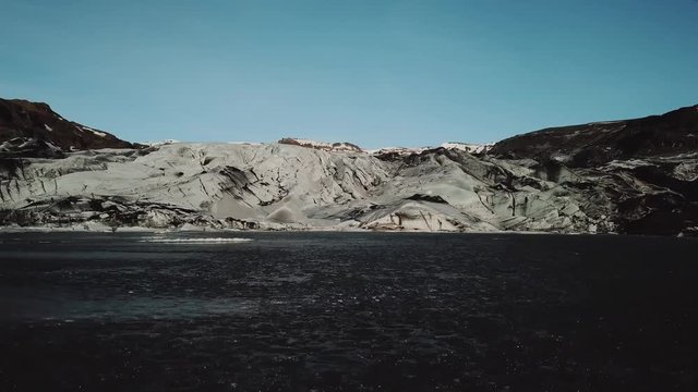 Iceland landscape of glacier Solheimajokull glacier. Beautiful nature aerial drone video of Icelandic nature. Tourist destination and attraction on South Iceland. Glacial lake / lagoon.