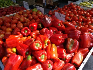 Pimientos rojos y tomates en parada de mercado