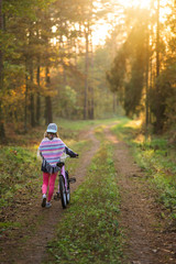 dziewczynka na rowerze w lesie. Piękna polska jesień © Piotr Szpakowski