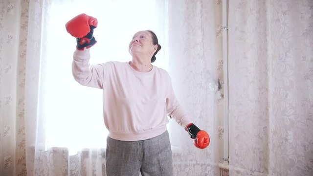 An old senior woman boxing in slow motion