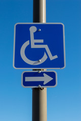 handicapped parking sign with arrow pointing to the right on pole