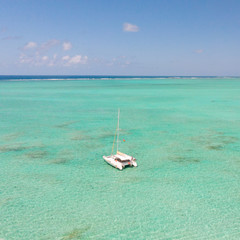 Aerial view of Catamaran boat sailing in turquoise lagoon of Ile aux Cerfs Island lagoon, Mauritius.