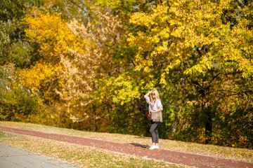 Photographing a girl during autumn in a park with a blurred background