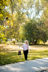 Fototapeta premium Photographing a girl during autumn in a park with a blurred background