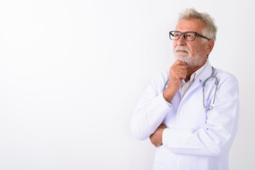 Studio shot of handsome senior bearded man doctor thinking again