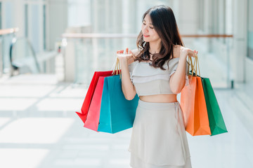 Happy woman holding colorful shopping bags