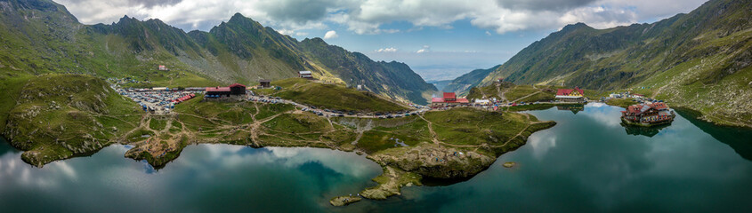 Aerial view of Balea lake and curving road of the Transfagaras pass in Romania - obrazy, fototapety, plakaty