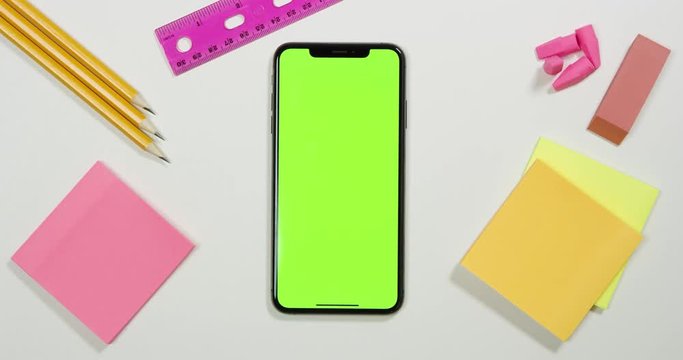 Using a green screen phone on a white work arts and crafts desk
