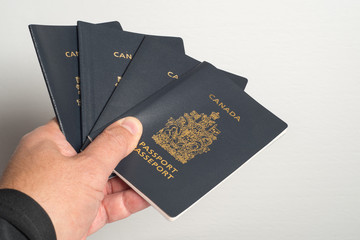 hand holding Canadian Passports, isolated on white background, ideal for travel ads tour visit Canada for tourists and immigrants issue passport matters