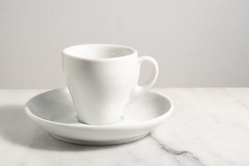 Fototapeta na wymiar Empty espresso coffee cup isolated over white granite or clear marble with white background