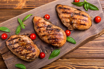 Grilled chicken breast ( fillet ) with basil and tomatoes