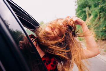 Wild girl riding around with her head out of the car window.