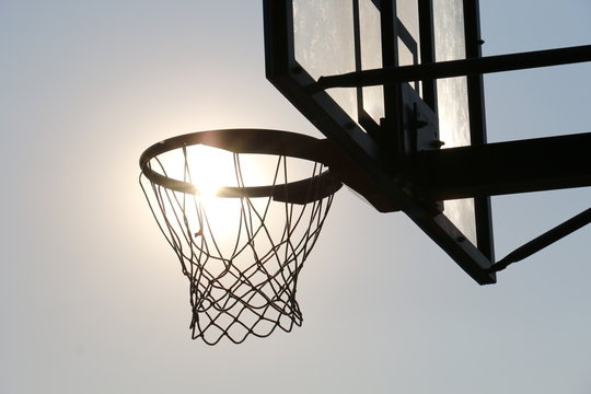 Basketball hoop on basketball court under syn