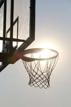 Basketball hoop on basketball court under syn