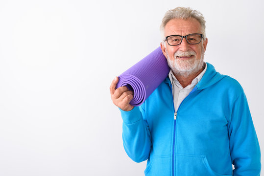 Studio shot of happy senior bearded man smiling while holding yo