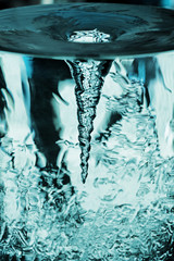 Vortex von Wasser im Glasrohr, Tornado, Sturm im Wasserglas mit drehender Luftsäule, Wasserröhre mit blauem Strudel