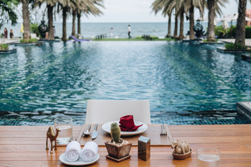 Obraz premium Table And Chair with Blur Swimming Pool Of The Background. Summer Vacation concept 