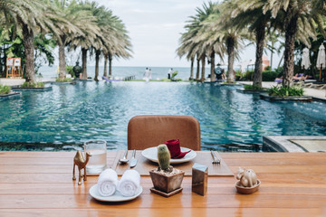 Obraz premium Table And Chair with Blur Swimming Pool Of The Background. Summer Vacation concept 