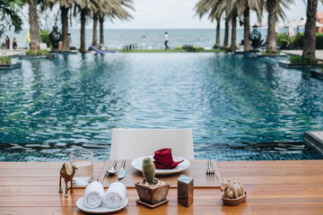 Obraz premium Table And Chair with Blur Swimming Pool Of The Background. Summer Vacation concept 