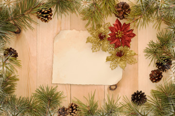 Christmas background with old paper, christmas decorations and fir tree on wooden board with copy space. Flat Lay. 