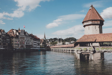 Lucerne, Switzerland - July 3, 2017: Panoramic view of city center of Lucerne with famous Chapel Bridge and river Reuss. Summer landscape, sunshine weather, dramatic sky and sunny day