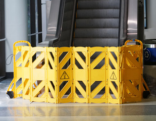warning barrier blocking escalator indoors for maintenance