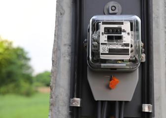 Closeup of electricity watt meter at the pole with natural background. 