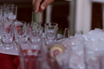 An image of clean and empty glasses and ice. The barman ice up cans of beer for cooling. Service concept and holiday concept. Background, cropped shot, isolated, close-up, blurred.