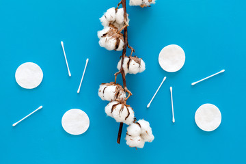 Bath accessories. Products for remove cosmetics. Cotton swabs and cotton pads on blue background top view