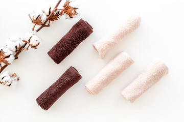 Cotton towels high quality. Set of towels twisted coil near dry cotton flowers on white background top view