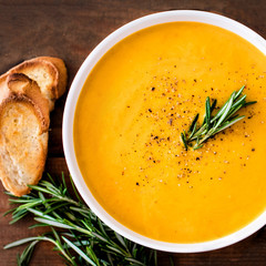 Pumpkin and carrot  Cream soup on  wood rustic  background. Autumn cream-soup in country style. Top view. Copy space.
