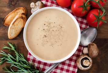 Mushroom cream soup with herbs and spices. Homemade, country style chanterelle Cream-soup on wooden table.
