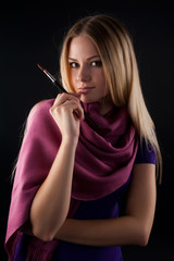 Obraz premium Beautiful young woman holding a paintbrushes over black background