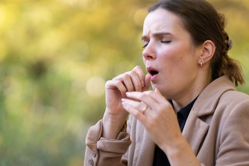 Young woman coughing or sneezing