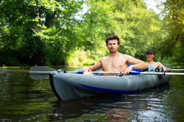 Two men in boatFriends are swimming on canoe