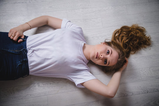 Girl in a white t-shirt lying on the floor