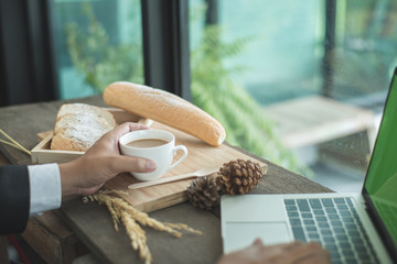 Businessman is working in coffee time with bread in the morning.