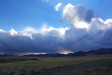 Landscape of highland steppe with mountains cloudy dramatic blue sky in during the evening time at Bayan-Ulgii, Mongolia
