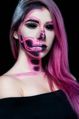 Halloween. Woman in day of the dead mask skull face art. Pink and black skull make up.